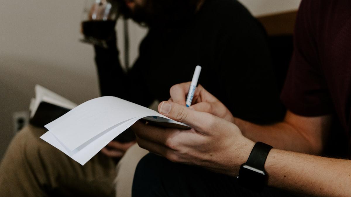 Two clinicians going over a stack of handwritten session notes together